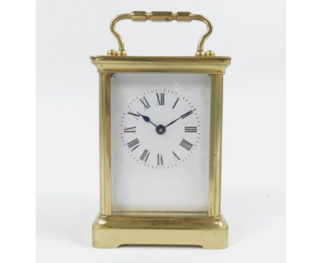 An early 20thC carriage clock, the white 5.5cm backplate with Roman numeric dial, in a rectangular case with swing handle, re