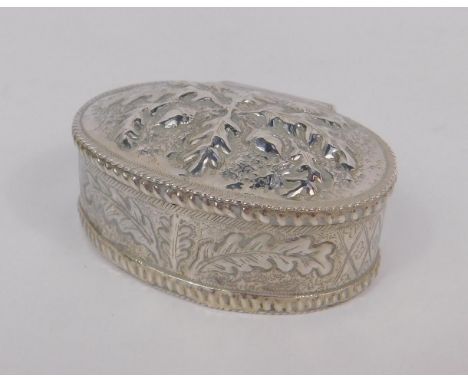 An Indian oval trinket box and winged lid, of oval form embossed with acorns and ferns, white metal, stamped sterling, 1.9oz.