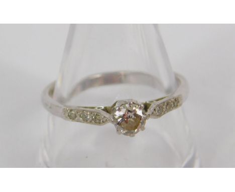 A diamond solitaire ring, set in white metal stamped 18ct, with diamond set shoulders, approx 0.3cts, size R, 2.4g.