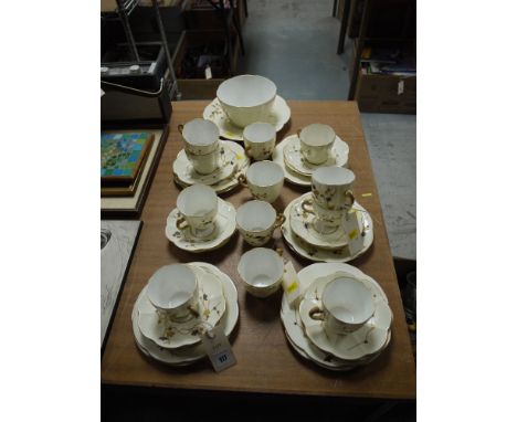 A late Victorian part afternoon tea set, decorated stylised shrubs on cream ground with gilded borders.