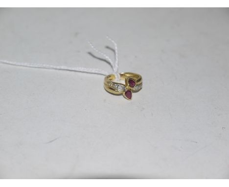 A ruby and diamond ring, the pear cut rubies collet set with three diamonds to each shoulder on a yellow metal mount, ring si