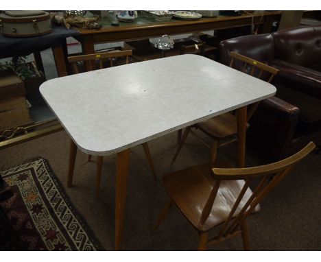 A rectangular marble effect melamine kitchen table, raised on turned tapering splayed legs; together with a set of three Erco