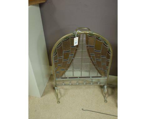 A late 19th Century brass framed firescreen with decorative leaded glass panel, raised on shaped feet.