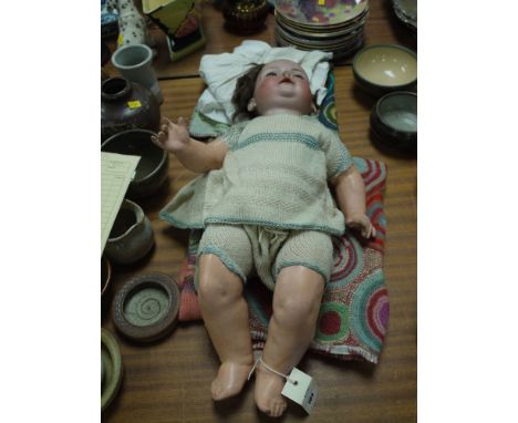 A large late 19th Century doll with ceramic head, rolling blue eyes, open mouth and real hair, impressed mark on the back of 