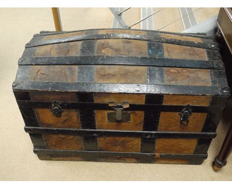 A 19th Century cabin trunk with shaped top, metal and wooden bindings over a hide covering, metal clasps, the top opening to 