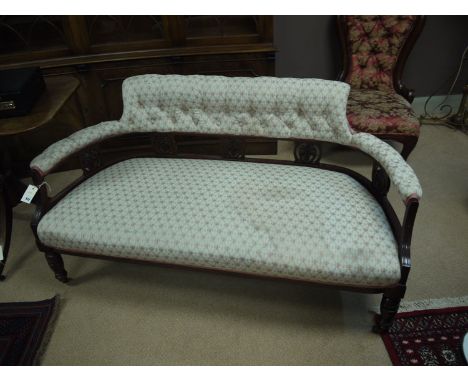 A late Victorian two-seater occasional settee with low shaped back with buttoned upholstery, the seat and back covered in cre