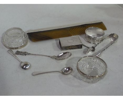 A silver matchbox cover; a white metal commemorative spoon; a Victorian pair of silver sugar tongs (repaired); silver napkin 