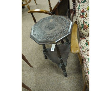 A carved oak octagonal table on turned legs with shelf under.