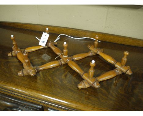 A Victorian stained wood wall mounted folding coat rack with seven pegs (missing some of the ceramic finials).