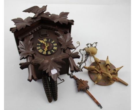 A mid-to-late 20th century Black Forest style cuckoo clock with weight and pendulum, height 38cm and a primitive handheld pec