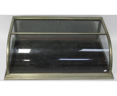 A curved glass and brass mirror-back table-top display cabinet, 97 x 30cm. CONDITION REPORT The brass has age-related wear an