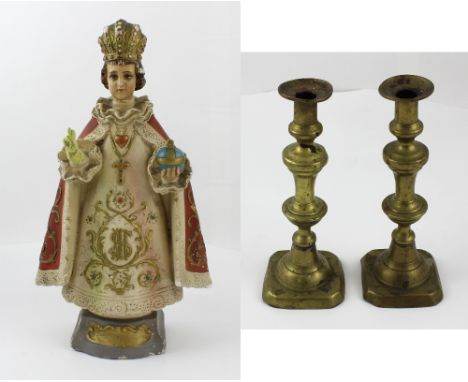 A vintage plaster model of 'The Infant of Prague' with orb (af), height 40cm, and a pair of brass candlesticks (3).