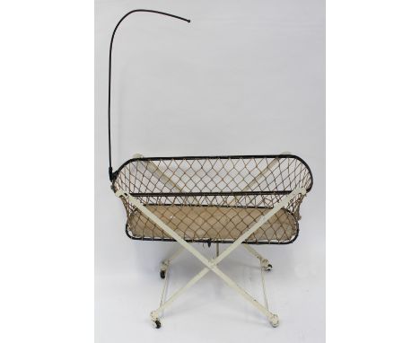 A vintage Edwardian wrought and cast iron dolls' crib with mobile arm, length 91.5cm.