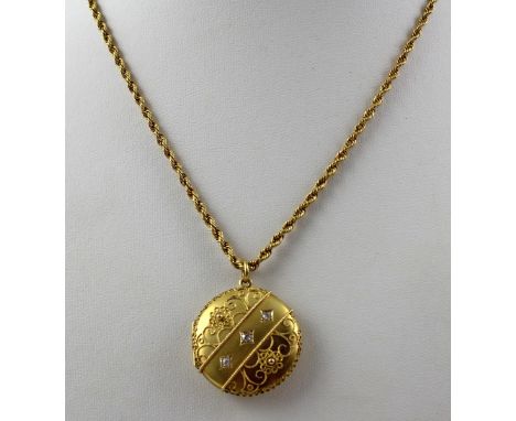 A 15ct gold disc-shaped locket with applied wirework and beadwork decoration and inset with three chip diamonds, presented on