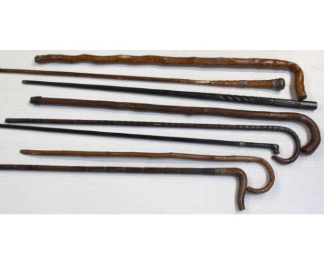 A group of vintage walking canes and sticks to include an ebony cane with incised carving, a horn-handled example with silver