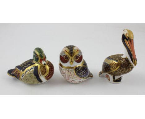 Three Royal Crown Derby paperweights to include the brown pelican, height 13cm, owl and duck, each with gold stopper (3).