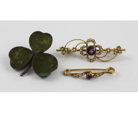 Two Edwardian amethyst and seed pearl set gold brooches of graduated size and a silver-mounted moss agate shamrock brooch, la