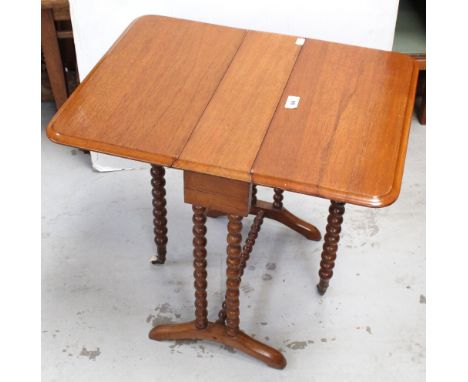 A late Victorian walnut Sutherland table, with bobbin turned supports, the swing legs with porcelain castors, width 48cm.