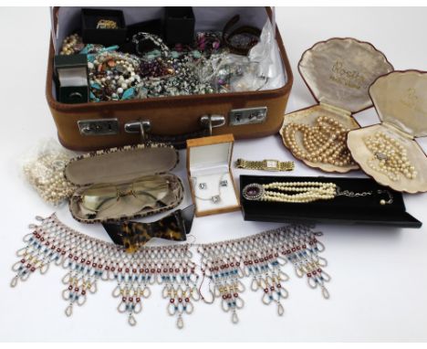 A canvas vanity case containing a quantity of vintage and later jewellery to include necklaces, bracelets, faux pearls, silve