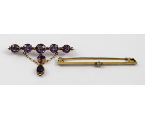 A good Edwardian amethyst bar brooch with five graduated amethysts surmounting a small circular pendant amethyst and a slight