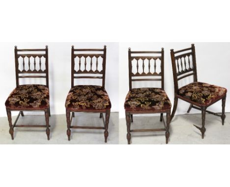 A set of four late Victorian walnut dining chairs with bobbin-turned backs over stuff-over seats supported on turned front le