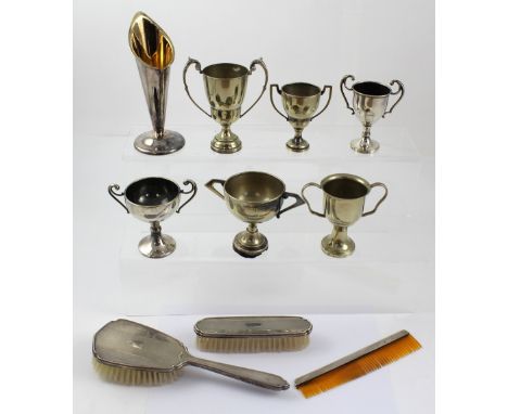 A three-piece hallmarked silver dressing table set comprising two brushes and a comb, a plated vase with gilt interior and a 