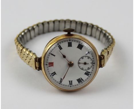 A 9ct gold ladies' trench watch, the dial set with Roman numerals and subsidiary seconds dial, presented on gold-plated elast