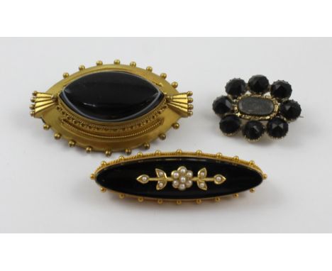 A Victorian elliptical bull's-eye agate mourning brooch with vacant hair compartment verso, diameter 4.5cm, a Victorian black