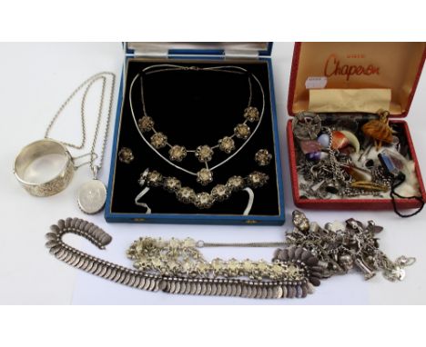 A quantity of silver and white metal jewellery to include a charm bracelet with over twenty charms, a Yemeni-style wedding ne