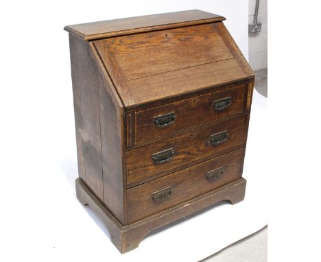 An Edwardian oak bureau with fitted interior and manual lopers, on a three-drawer plinth base, height 98cm.