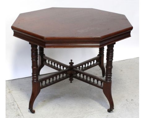 A late Victorian mahogany octagonal dining table on turned legs untied by X-framed bobbin turned stretcher to porcelain casto