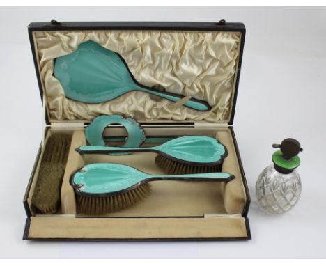 A hallmarked silver and enamelled engine-turned dressing table set comprising hand mirror, two hand brushes, clothes brush an