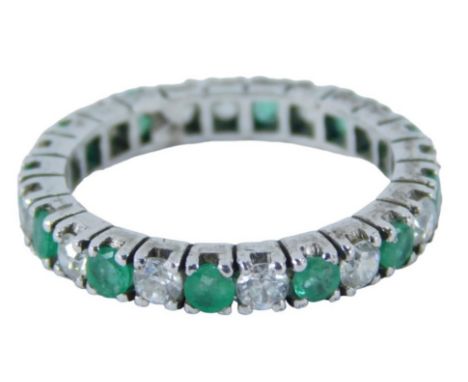 An emerald and diamond set eternity ring, round brilliant cut stones each in claw setting, on a white metal band, stamped 585