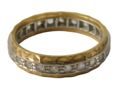 An 18ct gold diamond set eternity ring, the central band in white gold with faceted outer yellow metal band, ring size O, 3.8