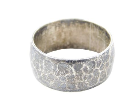 A silver wedding band, of plain hammered design, ring size V½.