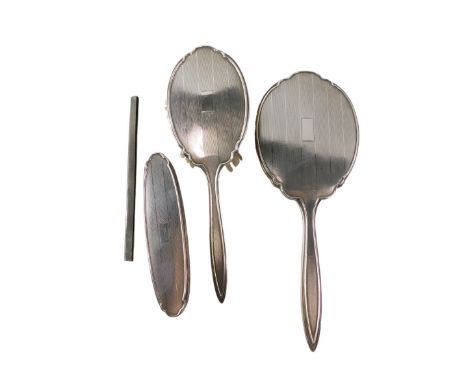 A George V silver four piece dressing table set, comprising brush, hand mirror, hand brush, and comb sleeve, with engine turn