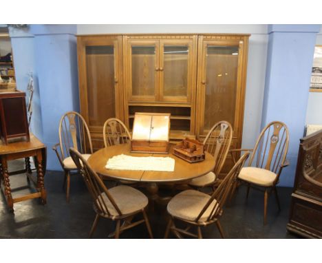 An Ercol dining room suite comprising extending table, six chairs and a three section display unit