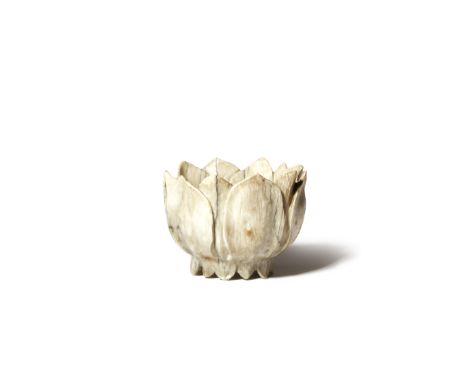 A CHINESE CHICKEN-BONE JADE 'LOTUS' CUP MING DYNASTY Formed as a single lotus flowerhead, the centre carved as seven seeds wi