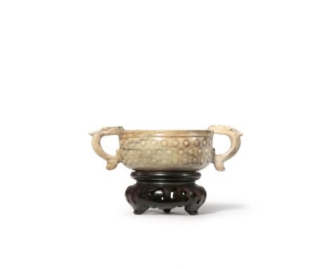 A CHINESE CHICKEN-BONE JADE TWO-HANDLED BOWL QING DYNASTY Carved in relief with a band of studs to the body, the two handles 