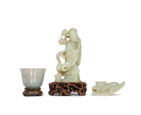 TWO CHINESE PALE CELADON JADE CARVINGS AND AN AGATE CUP QING DYNASTY One carving of a lady clasping a branch of fruiting peac