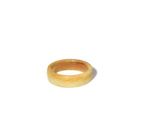A CHINESE CELADON JADE ARCHAISTIC BANGLE QING DYNASTY OR LATER Carved in shallow relief with two mythical creatures striding 
