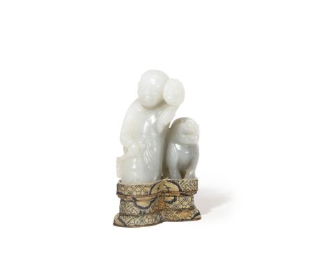 A CHINESE PALE CELADON JADE CARVING OF A FOREIGNER WITH A LION DOG QING DYNASTY The figure stands wearing a headband and a lo