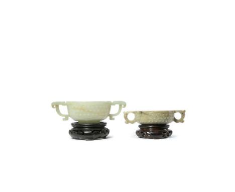 TWO CHINESE JADE TWO-HANDLED BOWLS MING AND QING DYNASTY Each carved with a band of raised studs, the larger cup a translucen