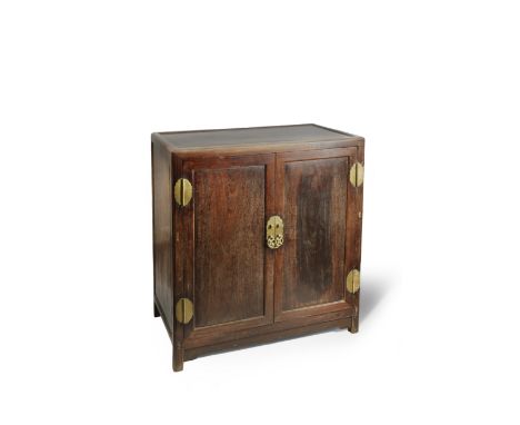 A CHINESE TIELIMU CABINET 19TH CENTURY With a rectangular hongmu top, four brass hinges to the pair of front door, two drawer