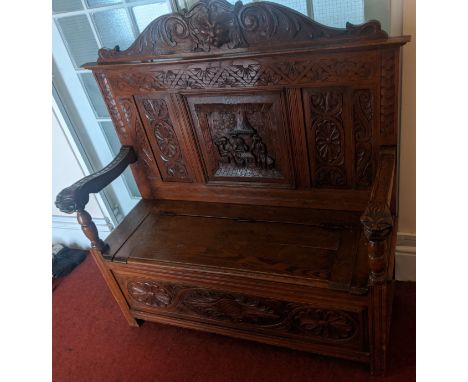 A Germanic oak hall bench, H.133cm W.125cm D.48cm