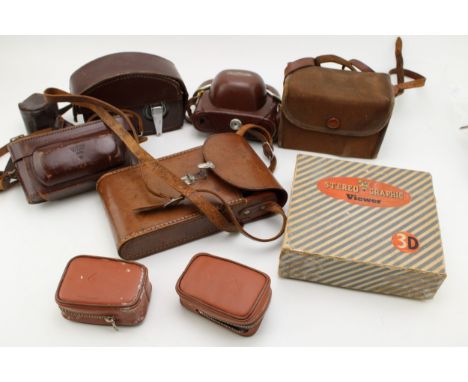 A collection of vintage cameras including a Wray Stereographic, a Voitlander, kodak, box Brownie and a Bell &amp; Howell cine