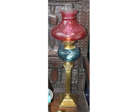 A large late 19th / early 20th century 'Duplex' oil lamp, blue glass bowl with cranberry glass shade raised on substantial br