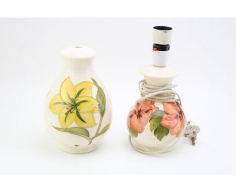 A Moorcroft lamp base in the 'Bermuda Lily' pattern together with another example in the 'Hibiscus' pattern. Height 21cm.  Of