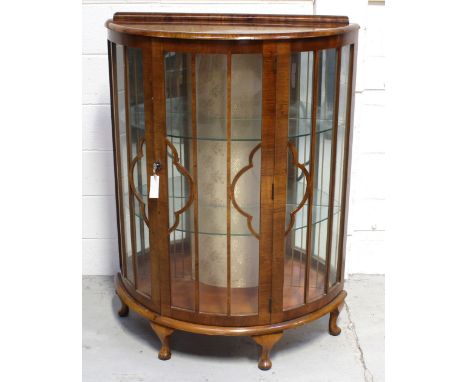 A c1940s mahogany bow-front display cabinet with two interior glass shelves to squat cabriole supports, height 180cm.