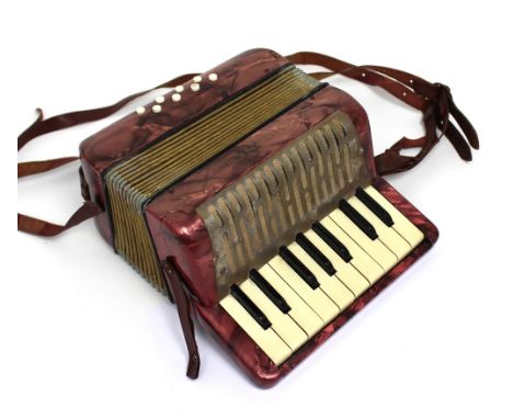 A small Hohner accordion.  CONDITION REPORT Seems to be in working order. Age-related wear. Strap in poor condition.